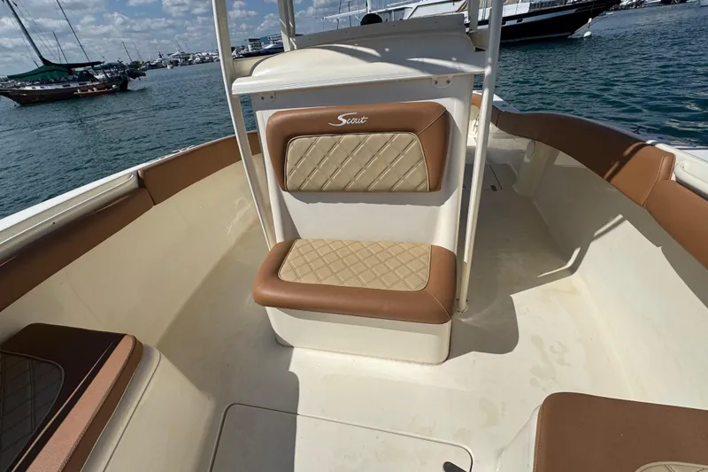 Slide: The Image of 2004 Scout 280 Sportfish boat interior with tan seating, docked in a marina. - 20