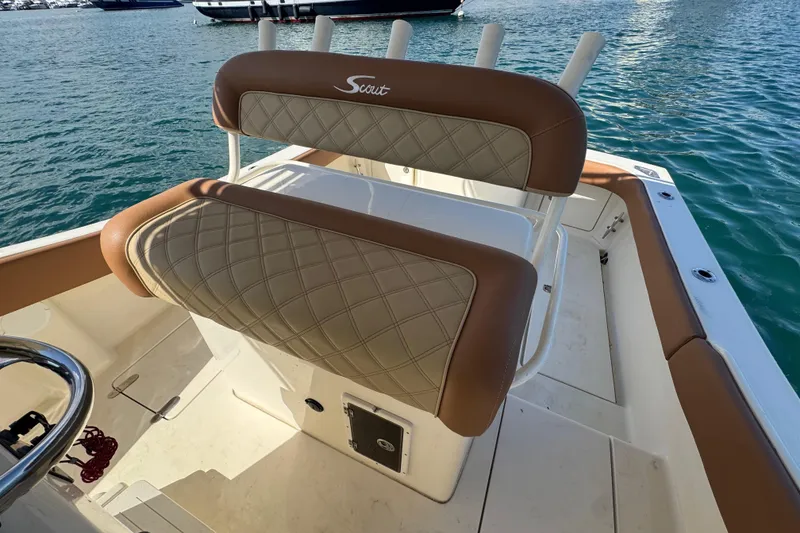 Slide: The Image of 2004 Scout 280 Sportfish boat with cushioned seating, docked on calm water. - 21