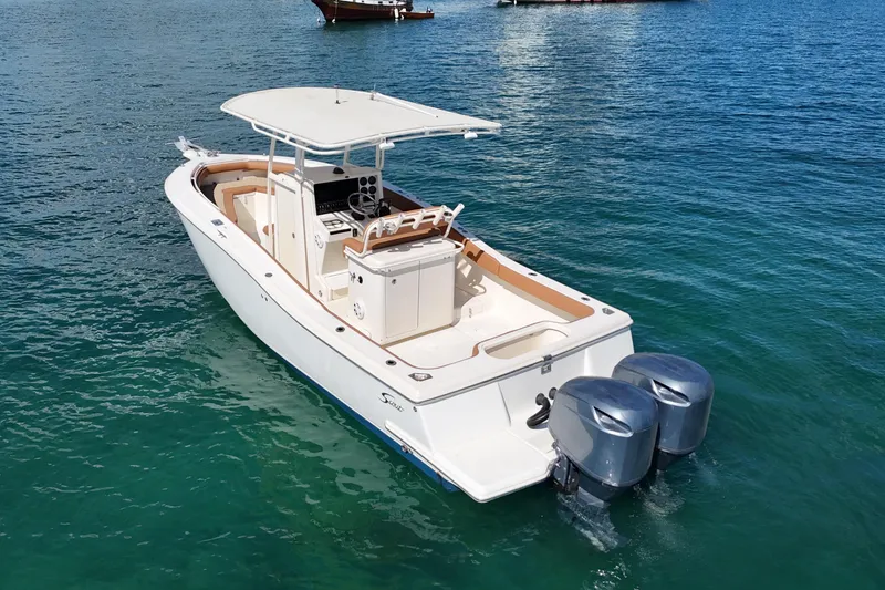 Slide: The Image of 2004 Scout 280 Sportfish boat with dual engines on clear blue water. - 4