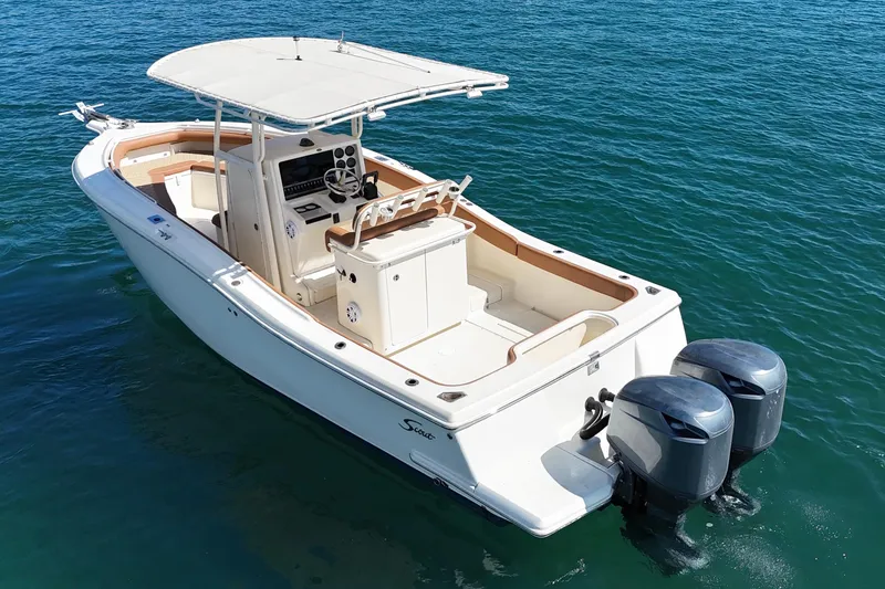 Slide: The Image of 2004 Scout 280 Sportfish boat with dual engines on clear blue water. - 5