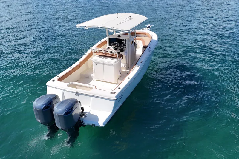 Slide: The Image of 2004 Scout 280 Sportfish boat with dual engines on clear blue water. - 6