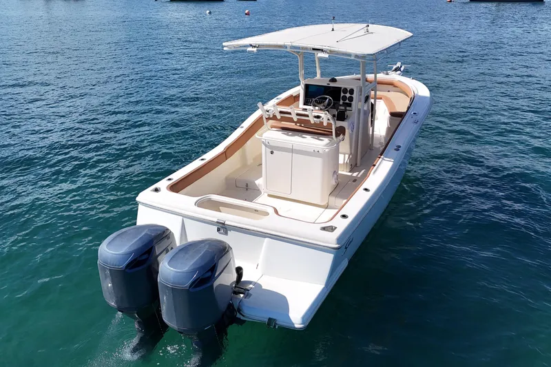 Slide: The Image of 2004 Scout 280 Sportfish boat with dual engines on clear blue water. - 7