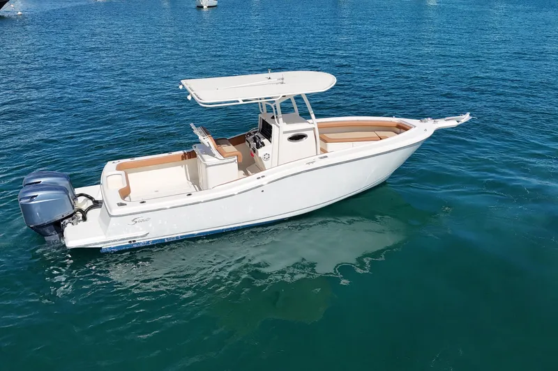 Slide: The Image of 2004 Scout 280 Sportfish boat on clear blue water, featuring twin engines and sleek design. - 8