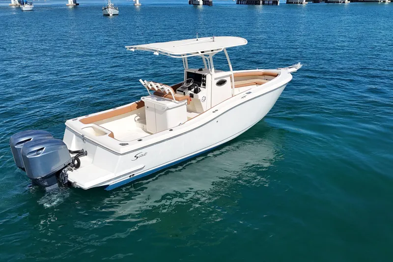 Slide: The Image of 2004 Scout 280 Sportfish boat on clear blue water, featuring dual outboard motors. - 9