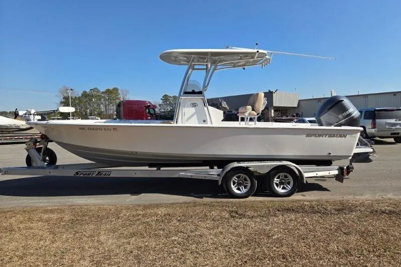 Slide: The Image of 2019 Sportsman Masters 247 Bay Boat on trailer, parked outdoors under clear blue sky. - 6