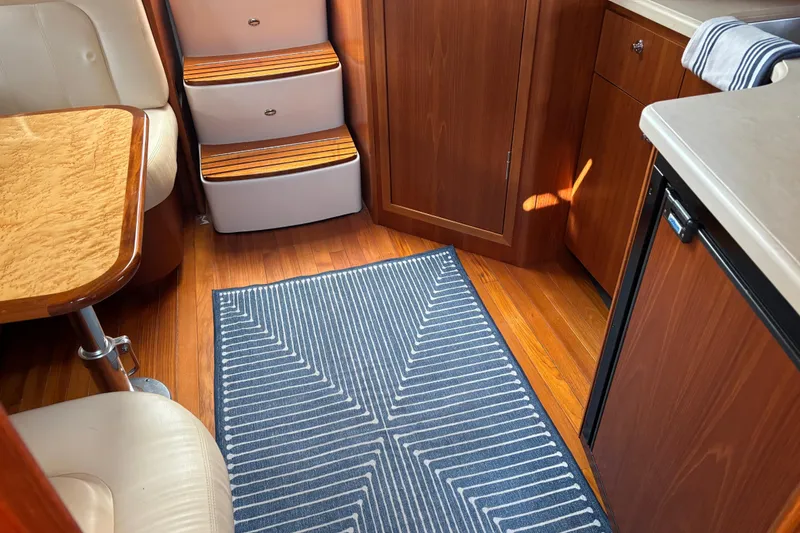 Slide: The Image of Interior of 2005 Tiara Yachts 3600 Open with wood flooring and striped rug. - 13