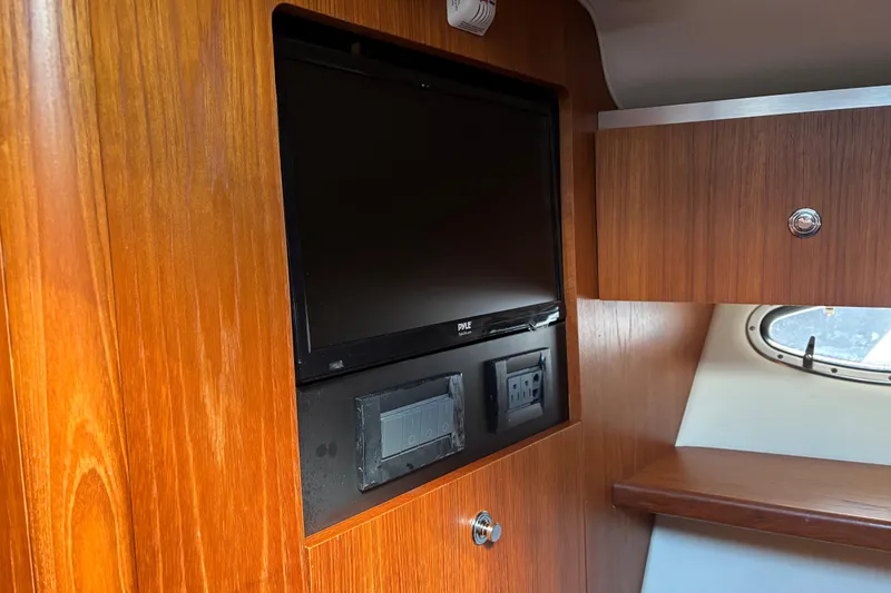 Slide: The Image of Wood-paneled interior of 2005 Tiara Yachts 3600 Open with built-in TV and porthole. - 14
