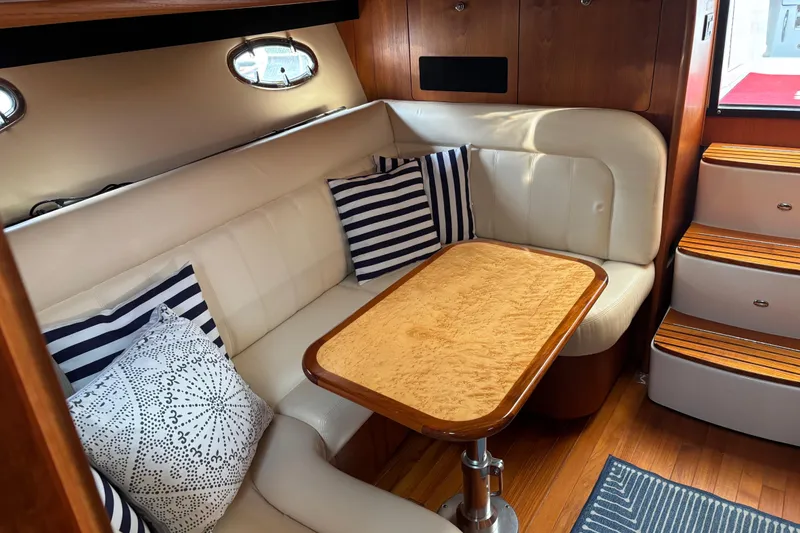 Slide: The Image of Interior of 2005 Tiara Yachts 3600 Open with cozy seating and striped cushions. - 16