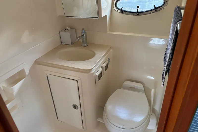 Slide: The Image of 2005 Tiara Yachts 3600 Open bathroom with sink, toilet, and porthole window. - 18