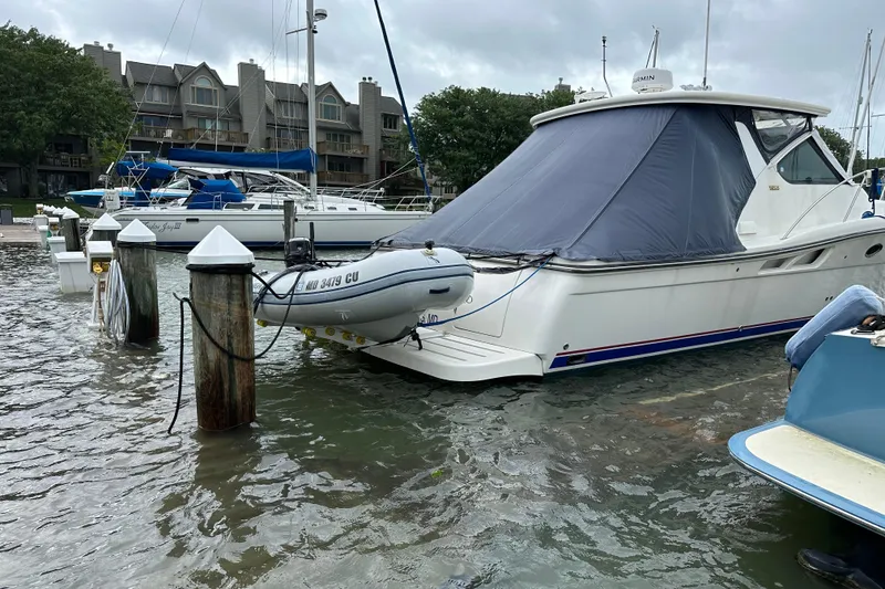 Slide: The Image of 2005 Tiara Yachts 3600 Open docked at marina with inflatable boat attached. - 2