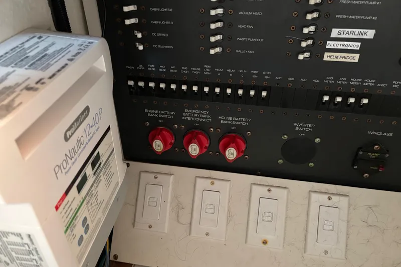 Slide: The Image of Electrical panel of a 2005 Tiara Yachts 3600 Open, featuring battery switches and ProNautic charger. - 27