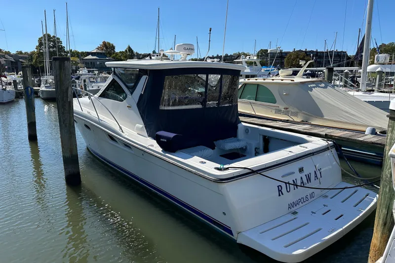 Slide: The Image of 2005 Tiara Yachts 3600 Open docked in marina, rear view with "Runaway" name. - 3