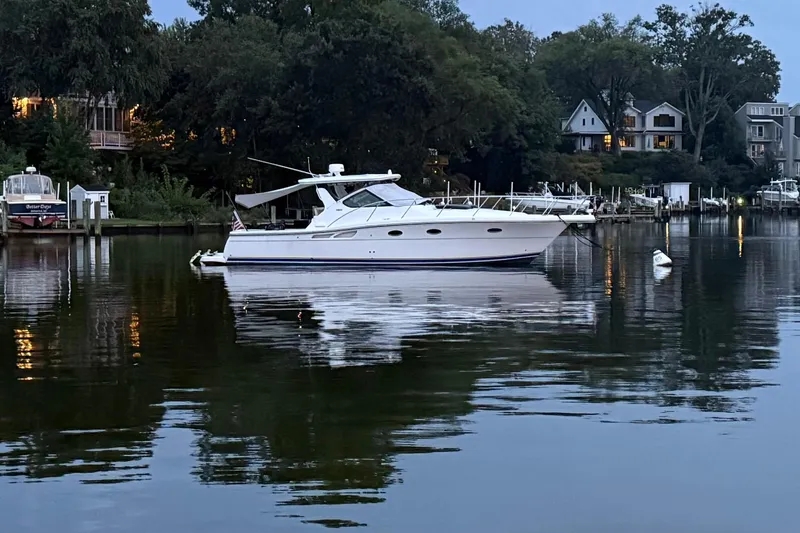 Slide: The Image of 2005 Tiara Yachts 3600 Open boat on calm water near shoreline homes. - 4