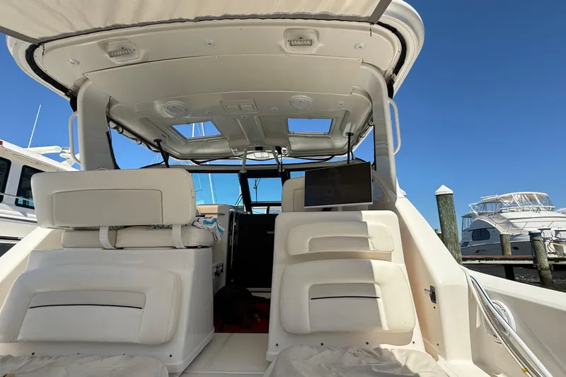 Slide: The Image of 2005 Tiara Yachts 3600 Open interior view at marina, showcasing seating and helm area. - 7
