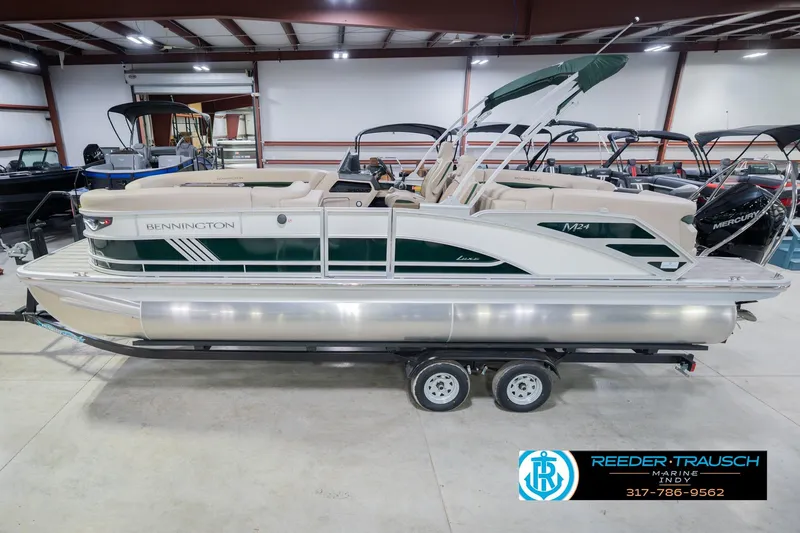 The Image of 2026 Bennington 24 MFB pontoon boat in showroom, side view with trailer. - 1