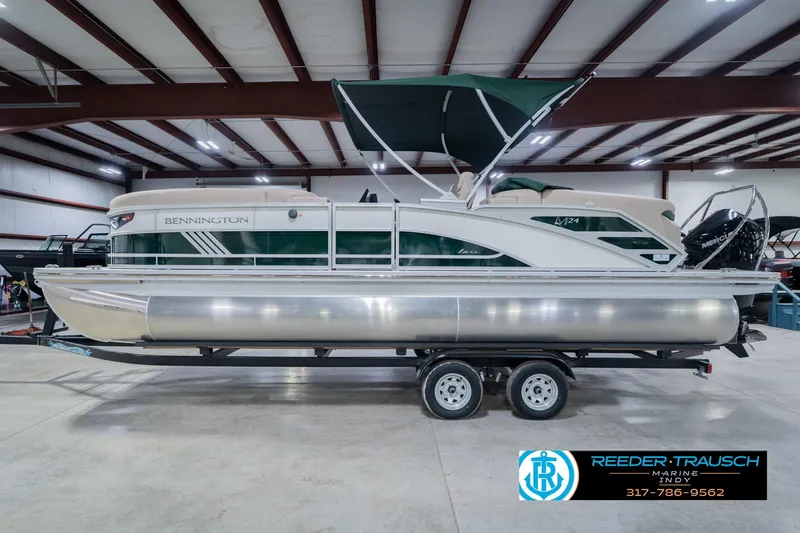 Slide: The Image of 2026 Bennington 24 MFB pontoon boat in showroom, side view with trailer. - 10