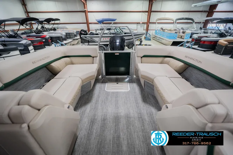 Slide: The Image of 2026 Bennington 24 MFB pontoon boat interior with plush seating in a showroom. - 17