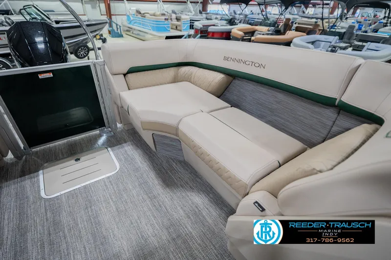 Slide: The Image of 2026 Bennington 24 MFB boat interior with beige seating and green accents in showroom. - 30