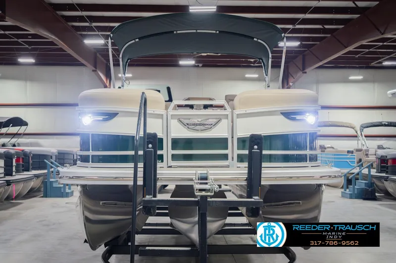 Slide: The Image of 2026 Bennington 24 MFB pontoon boat in showroom, front view with lights on. - 4