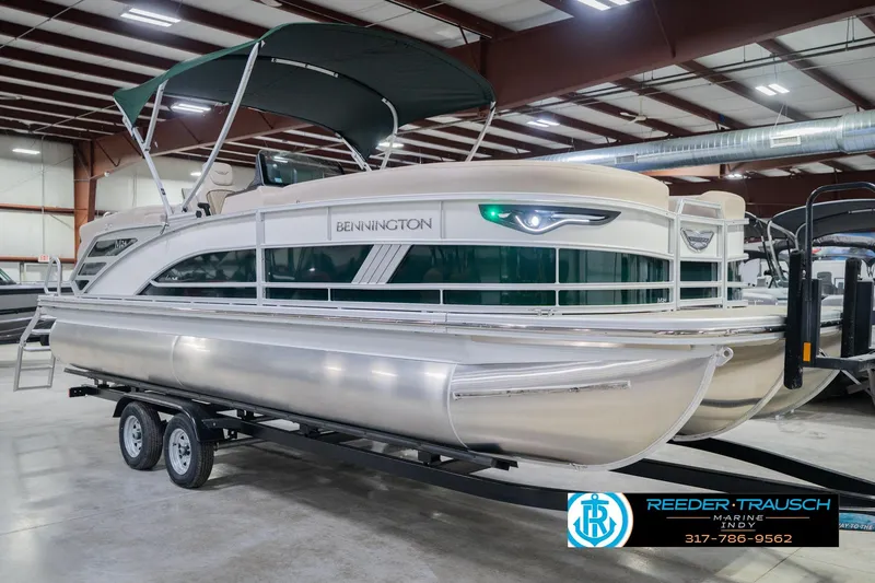 Slide: The Image of 2026 Bennington 24 MFB pontoon boat in showroom, featuring sleek design and canopy. - 5