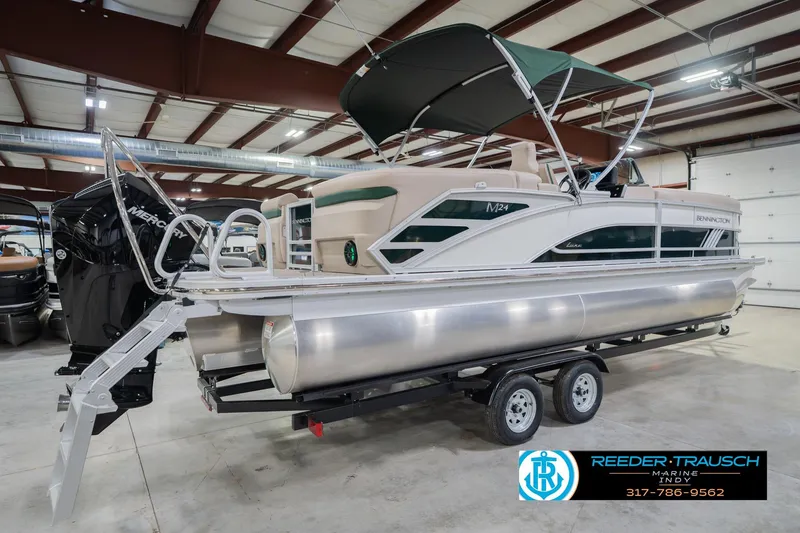Slide: The Image of 2026 Bennington 24 MFB pontoon boat in showroom, featuring sleek design and Mercury engine. - 7