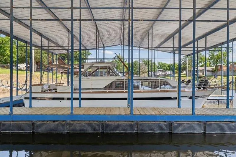 The Image of 1964 Chris-Craft 37 Constellation docked under covered marina. - 1