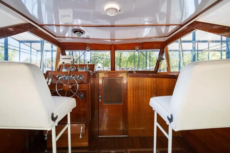 Slide: The Image of Interior of a 1964 Chris-Craft 37 Constellation boat with wooden helm and white seats. - 14