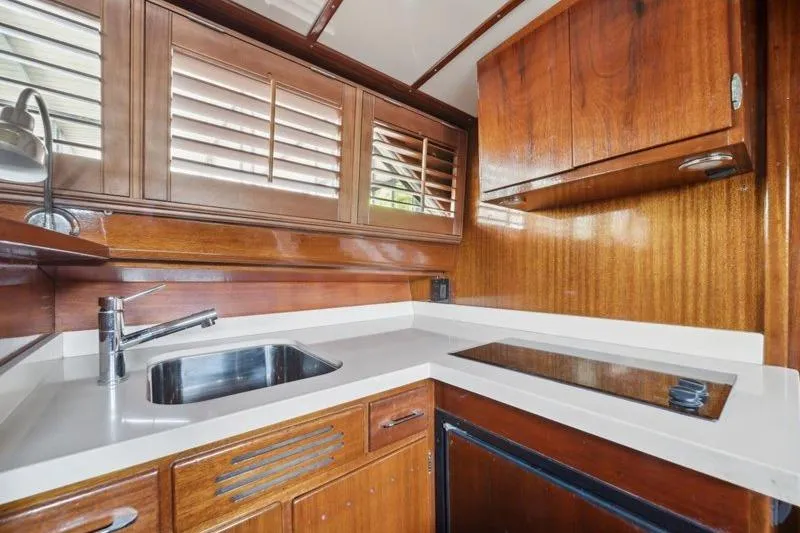 Slide: The Image of 1964 Chris-Craft 37 Constellation yacht kitchen with wooden cabinetry and modern fixtures. - 18