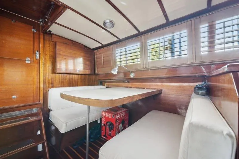 Slide: The Image of 1964 Chris-Craft 37 Constellation interior with wood paneling and cozy seating area. - 19