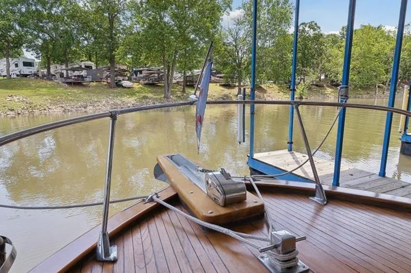 Slide: The Image of 1964 Chris-Craft 37 Constellation boat docked by a serene riverside with lush greenery. - 29