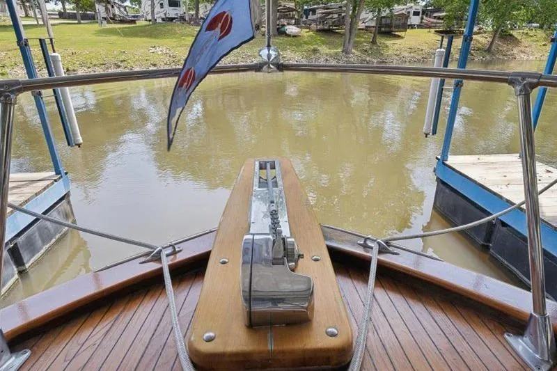 Slide: The Image of 1964 Chris-Craft 37 Constellation boat deck with flag, docked on a calm river. - 30