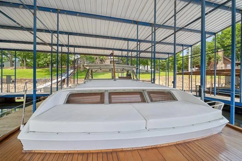 Slide: The Image of 1964 Chris-Craft 37 Constellation docked under covered marina, showcasing classic design. - 31