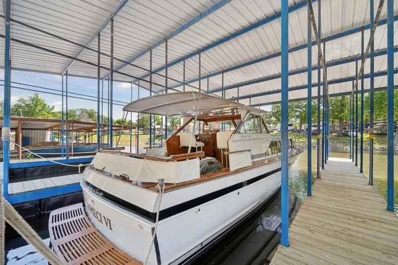 Slide: The Image of 1964 Chris-Craft 37 Constellation docked under covered marina, showcasing classic design. - 7