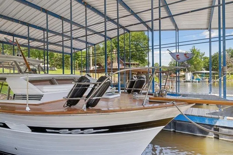 Slide: The Image of 1964 Chris-Craft 37 Constellation docked under covered marina, showcasing classic wooden design. - 8