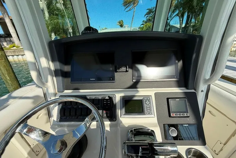 Slide: The Image of 2012 Boston Whaler 250 Outrage helm with steering wheel and navigation displays. - 12