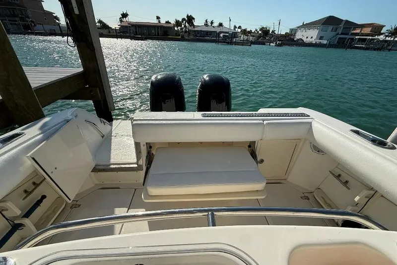 Slide: The Image of 2012 Boston Whaler 250 Outrage boat interior with dual engines, docked by the water. - 23