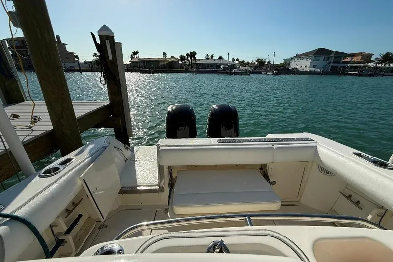 Slide: The Image of 2012 Boston Whaler 250 Outrage boat docked, featuring dual engines and spacious seating. - 24