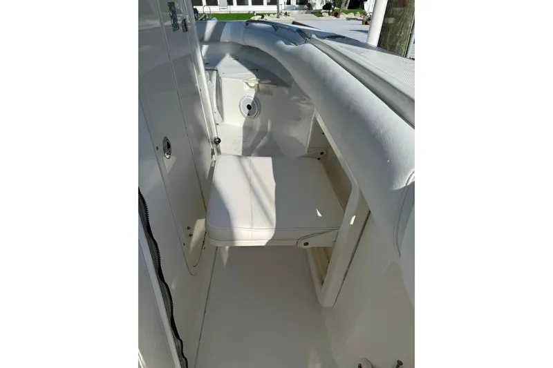 Slide: The Image of 2012 Boston Whaler 250 Outrage interior with white seating and storage area. - 26