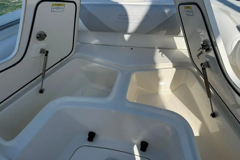 Slide: The Image of 2012 Boston Whaler 250 Outrage storage compartments with open hatches, showcasing interior space. - 3