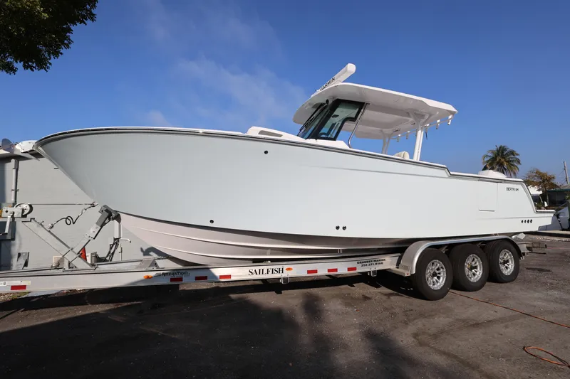 Slide: The Image of 2023 Bertram 28 CC boat on trailer, side view, clear sky background. - 1