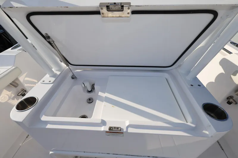 Slide: The Image of 2023 Bertram 28 CC boat sink with open lid and cup holders. - 11