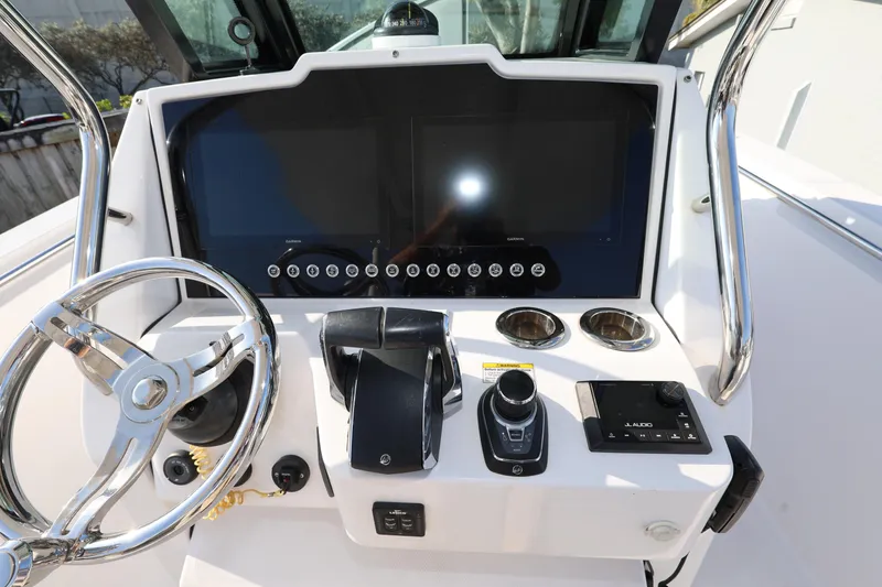 Slide: The Image of 2023 Bertram 28 CC boat dashboard with steering wheel and modern controls. - 13