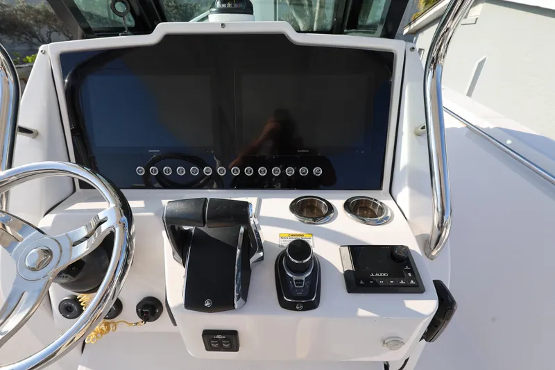 Slide: The Image of 2023 Bertram 28 CC helm with dual screens, steering wheel, and control panel. - 14