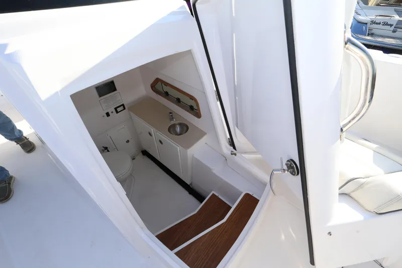 Slide: The Image of 2023 Bertram 28 CC boat interior with compact bathroom and sink area. - 20