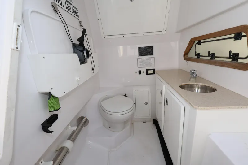 Slide: The Image of 2023 Bertram 28 CC boat interior with toilet, sink, and storage cabinets. - 21