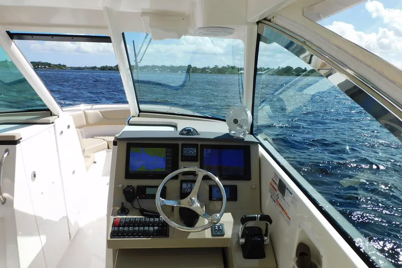Slide: The Image of 2016 Pursuit DC 325 Dual Console boat interior with navigation system on open water. - 14