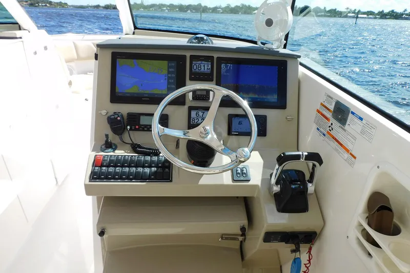 Slide: The Image of 2016 Pursuit DC 325 Dual Console boat dashboard with navigation screens and controls. - 15