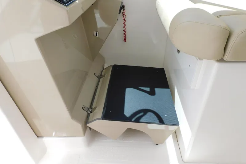 Slide: The Image of 2016 Pursuit DC 325 Dual Console interior step detail with beige seating and console. - 16