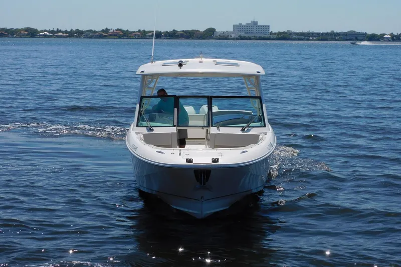 Slide: The Image of 2016 Pursuit DC 325 Dual Console boat cruising on open water. - 2