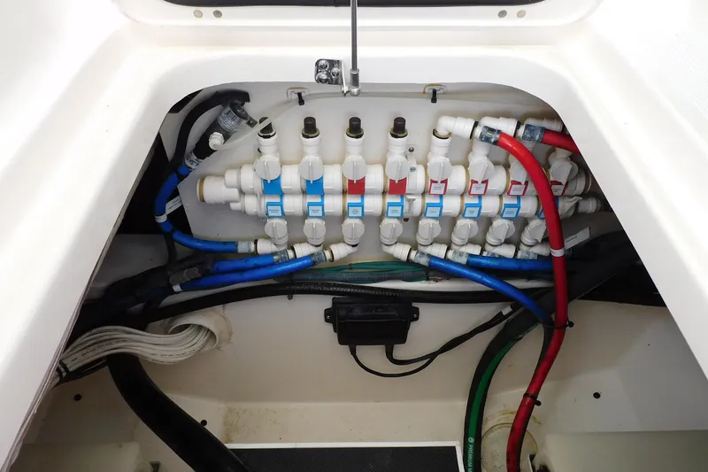 Slide: The Image of 2016 Pursuit DC 325 Dual Console boat plumbing system with labeled valves and colored hoses. - 24